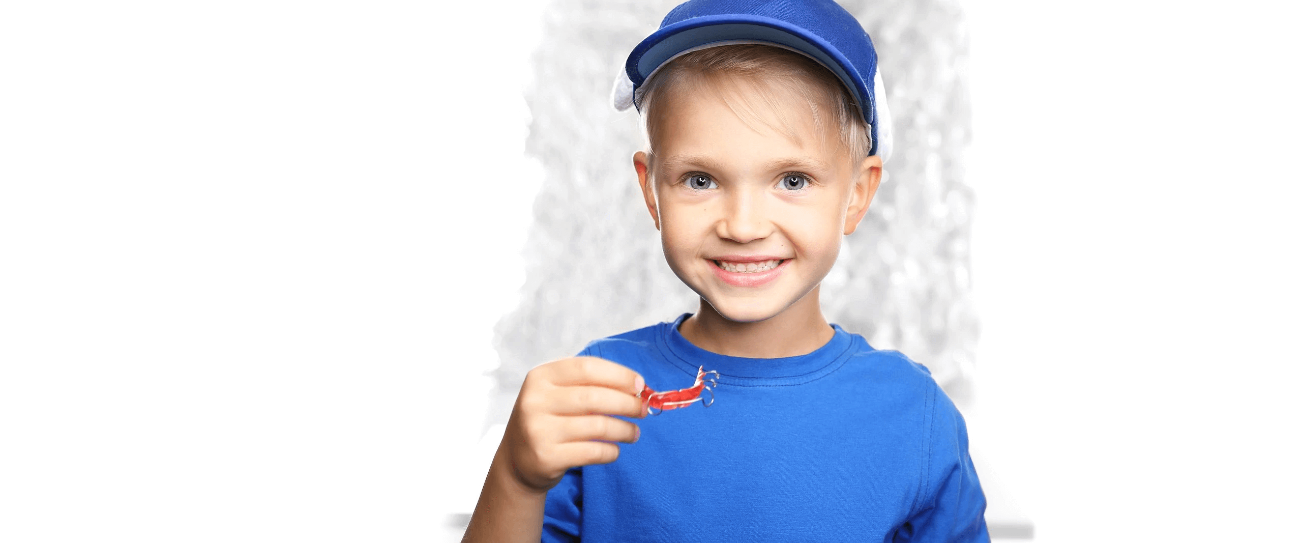 Chłopiec w niebieskim ubraniu z aparatem ortodontycznym ruchomym