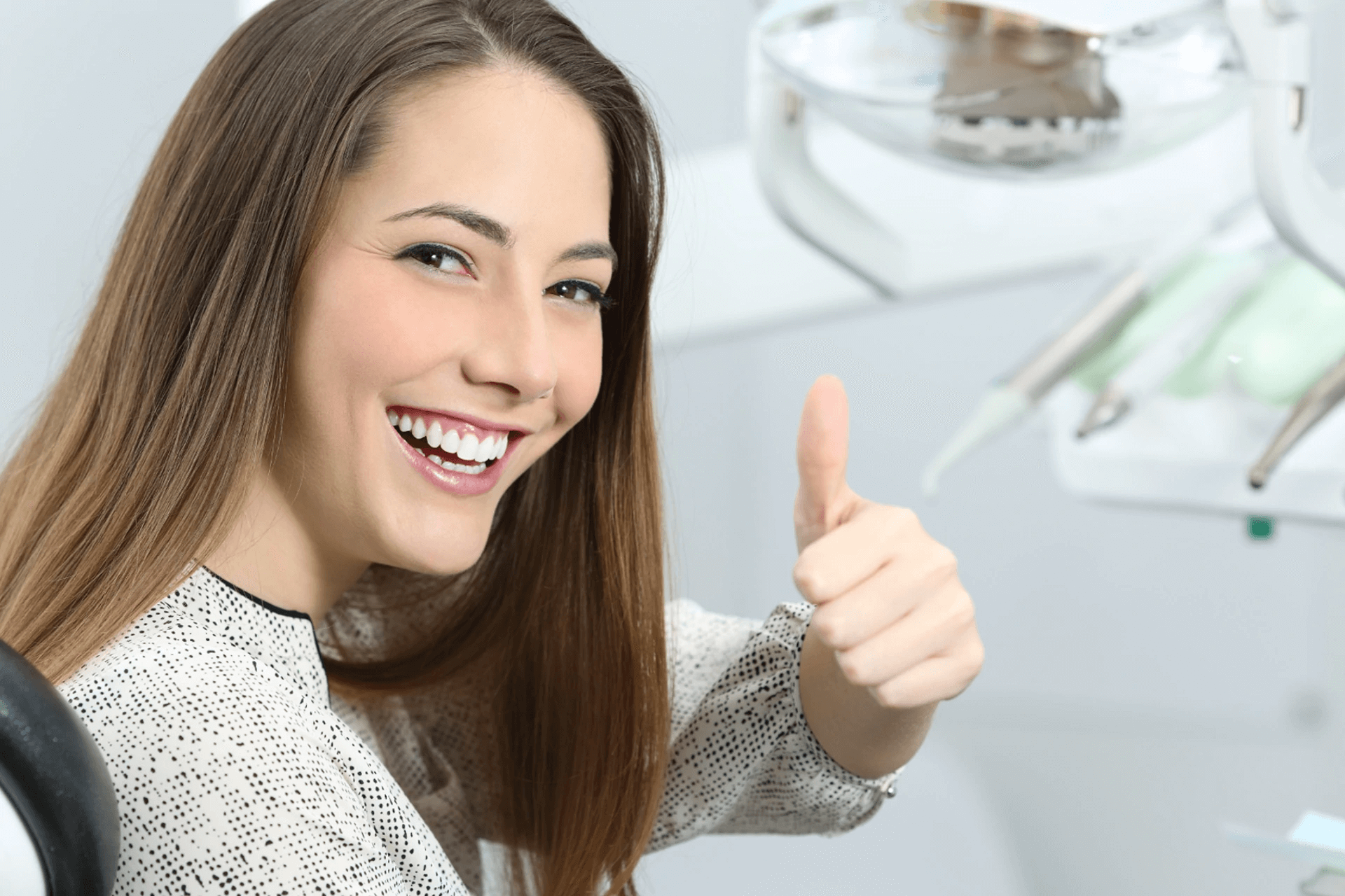 uśmiechnięta kobieta podczas wizyty na fotelu u ortodonty
